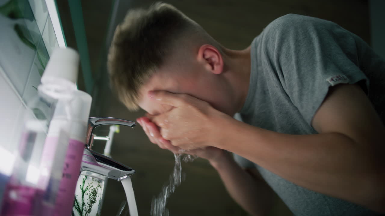 십대가 화장실에서 손을 고 있다