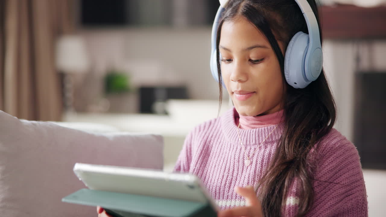 Girl with headphones using a tablet at home