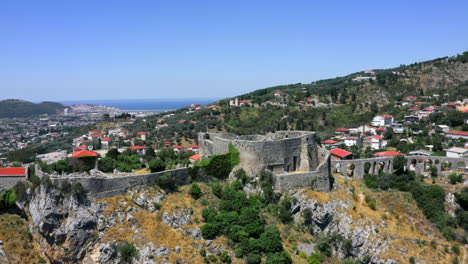 Rotating-aerial-4k-shot-of-the-old-Stari-Bar-fortress-in-Montenegro-with-the-city-of-Bar-and-the-Adriatic-sea-in-the-background-on-a-cloudless-sunny-summer-day