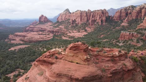 Hombre-Que-Se-Acerca-Aéreo-Encima-De-Formaciones-De-Rocas-Rojas,-Sedona,-Arizona