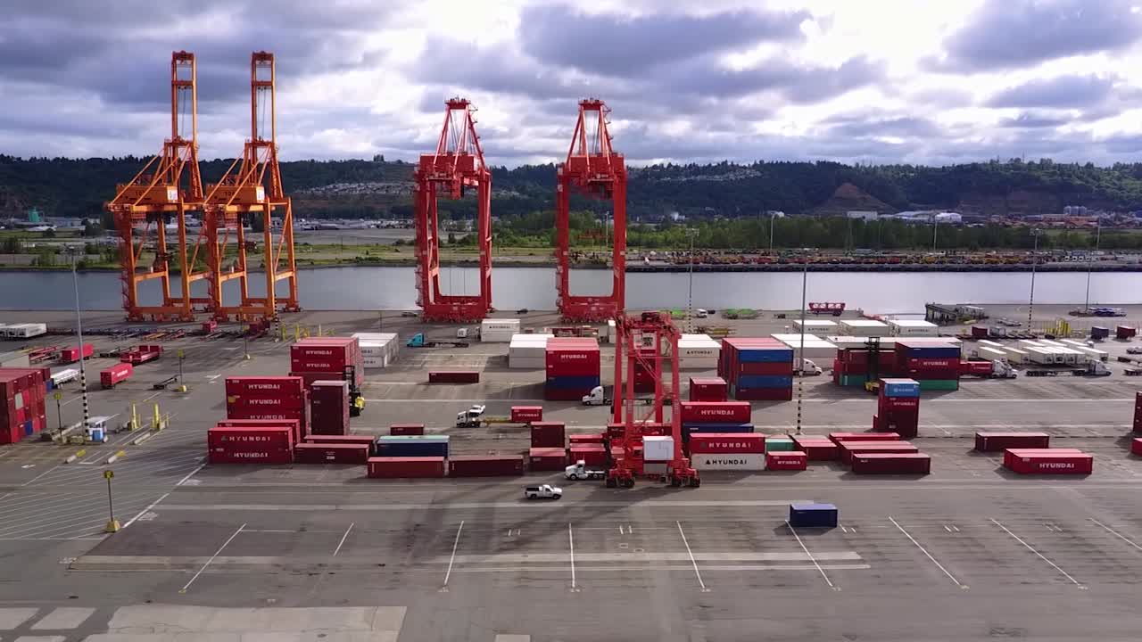 워싱턴주 타코마의 타코마 갯벌에 있는 노란색 및 빨간색 화물 크레인 - 패닝 샷