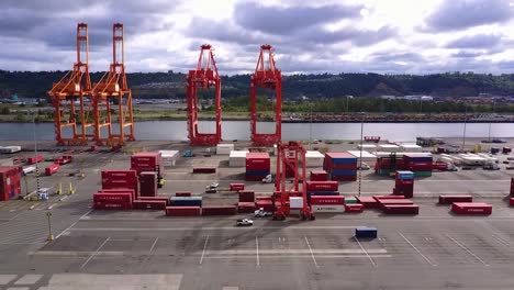 yellow and red cargo cranes at the tacoma tideflats in tacoma, washington - panning shot