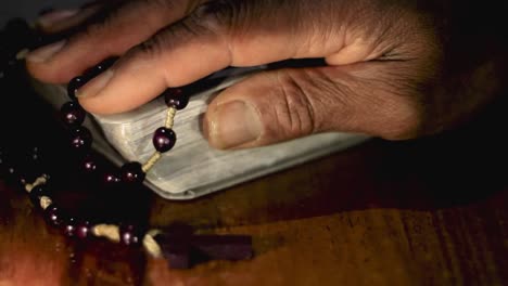 praying-to-god-with-hands-together-with-bible-and-cross-Caribbean-man-praying-with-black-background-stock-video