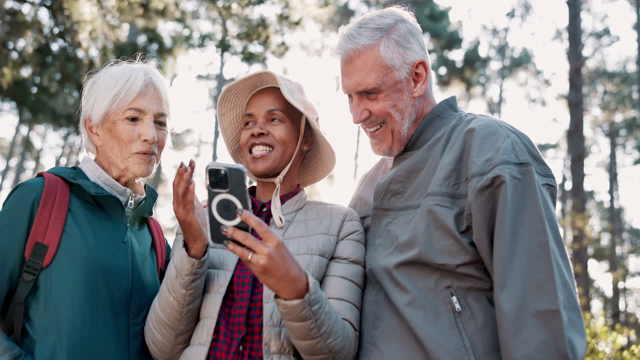 amigos mayores disfrutando de una caminata y compartiendo un momento en su teléfono