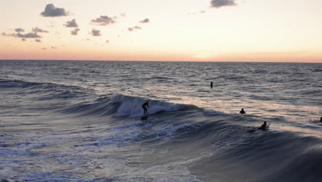 surfistas frente a la ciudad turística domburg en los países bajos durante la puesta de sol