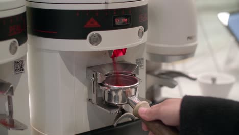 el portafilter es recogido y colocado para ser llenado con café molido fresco