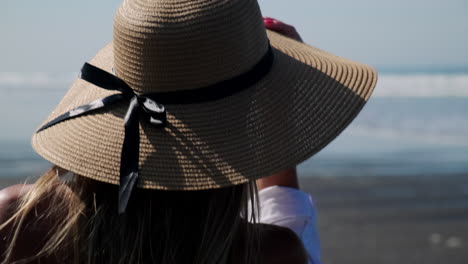 mujer en la playa con sombrero de paja