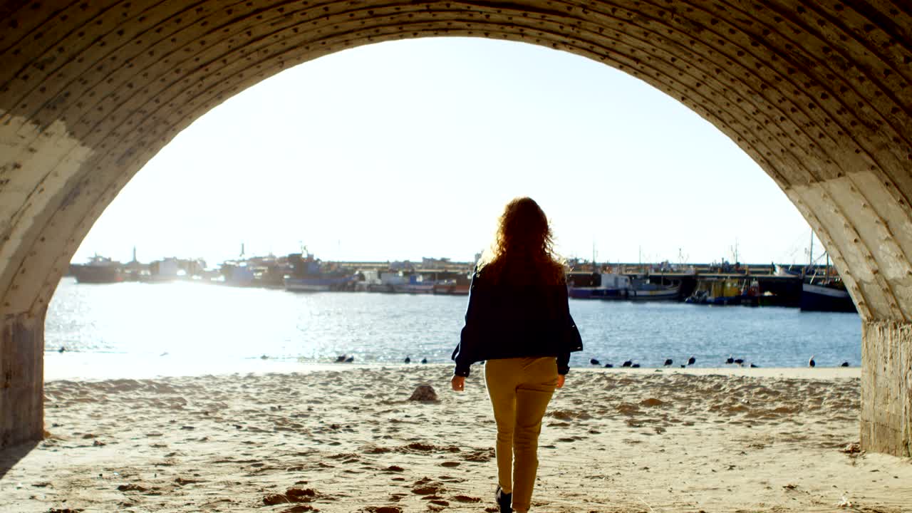 mujer de pie con los brazos extendidos en el muelle 4k