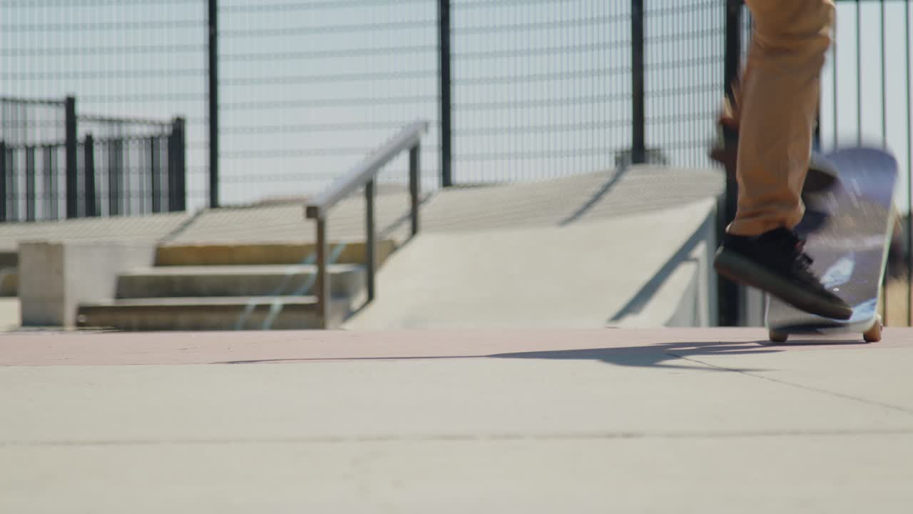 A skateboarder executes a flip trick on flat ground at the skatepark