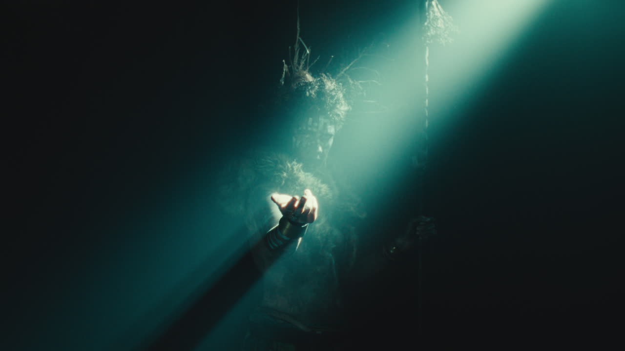 The witch makes a beckoning gesture with her hand