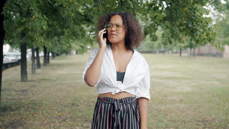 young woman talking on phone in a park