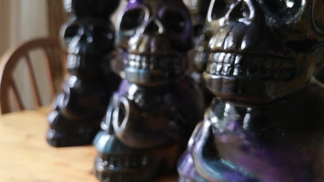 Colourful painted ceramic spooky death skull totem crafts pottery ornament shallow focus push in