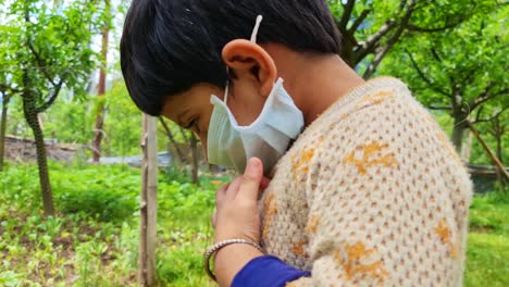 small masked indian girl wear medical mask is looking to camera during the second wave of coronavirus in india 2021