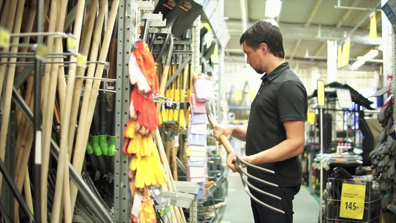 하드웨어 가게 에서 정원 도구 를 구입 하는 사람