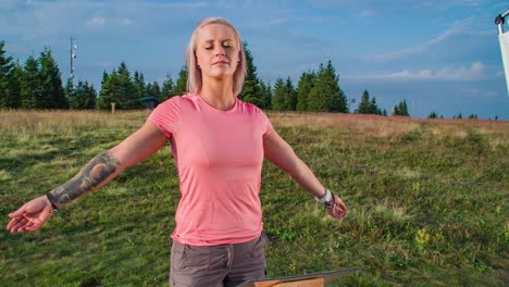 Slow-motion-shot-of-a-woman-standing-with-her-arms-spread-on-a-healing-point