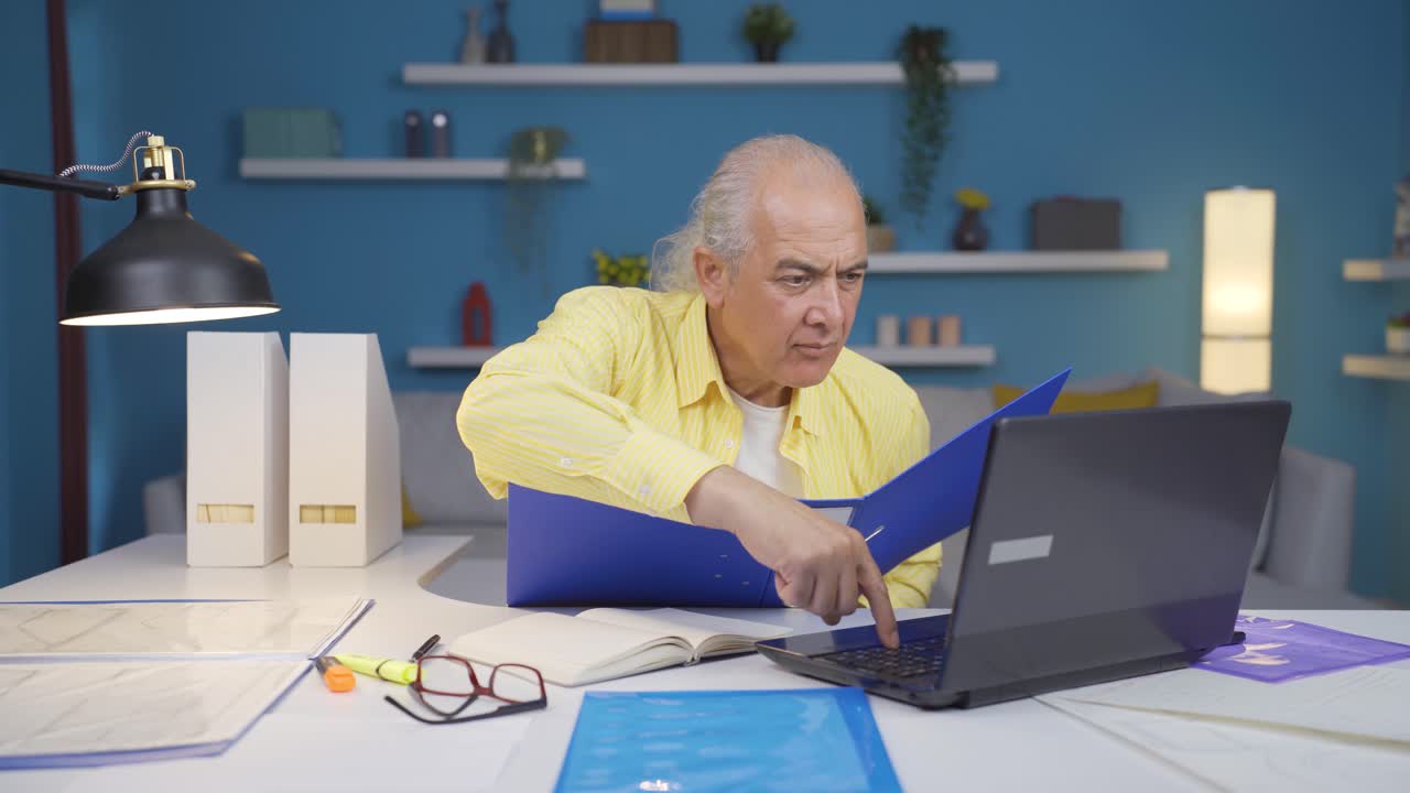 Home office worker old man reviewing paperwork files.