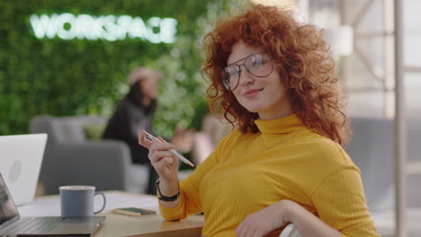 portrait-beautiful-young-redhead-business-woman-smiling-happy-entrepreneur-enjoying-successful-career-in-trendy-startup-office-wearing-glasses