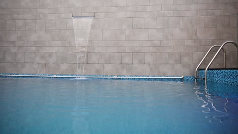 Pan-left-shot-of-swimming-pool-with-waterfall