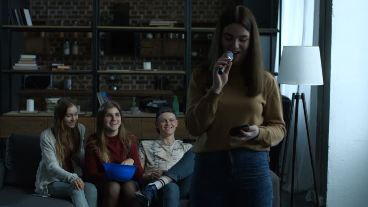 chica linda cantando karaoke en el micrófono en casa