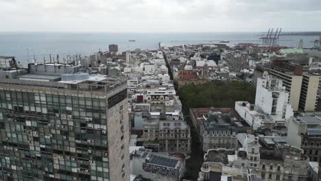 Drone-Acercándose-A-La-Capital-Metropolitana-De-Montevideo-De-Uruguay-Con-Un-Moderno-Edificio-De-Rascacielos-Que-Revela-El-Paisaje-Urbano-Sobre-El-Océano-Atlántico