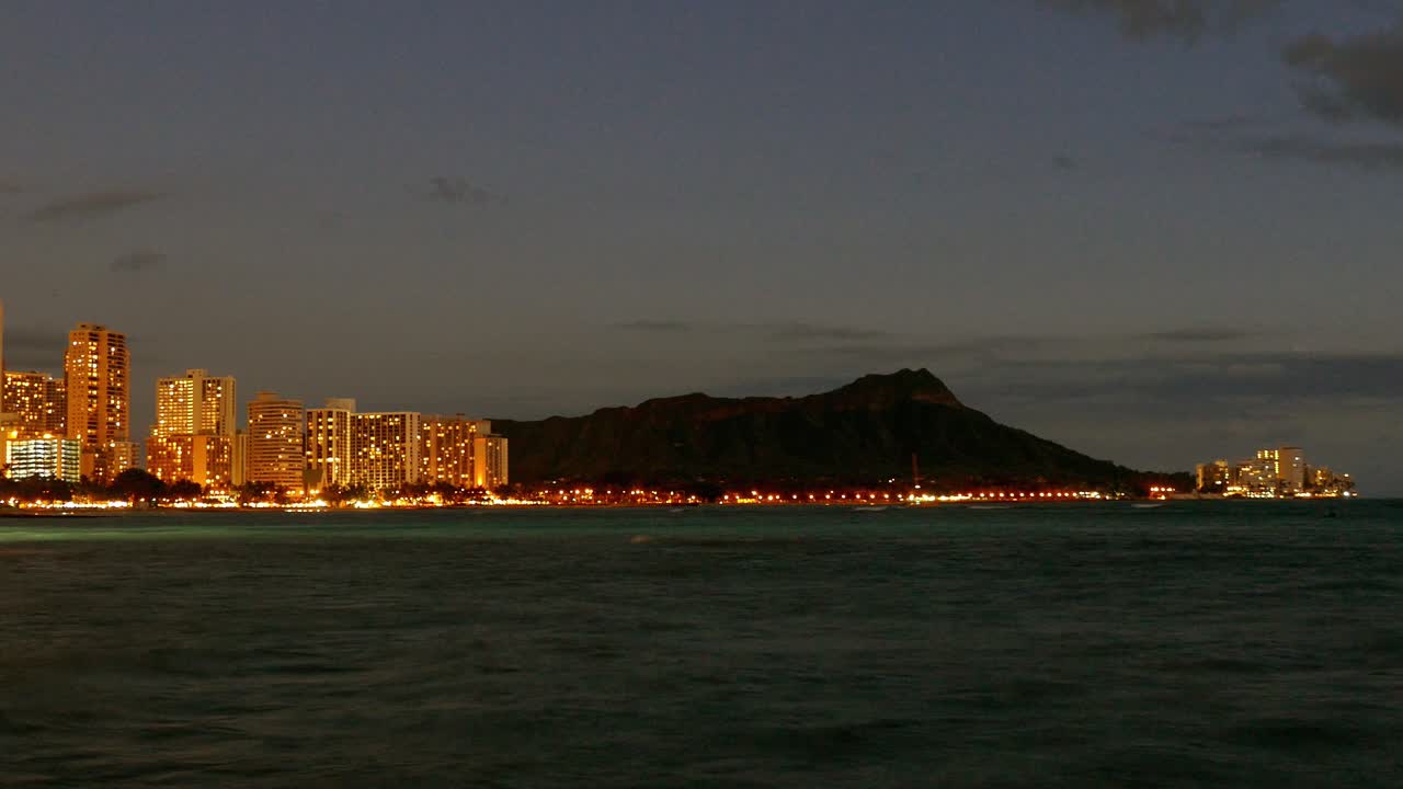 Skyline di Honolulu di notte con Diamond Head