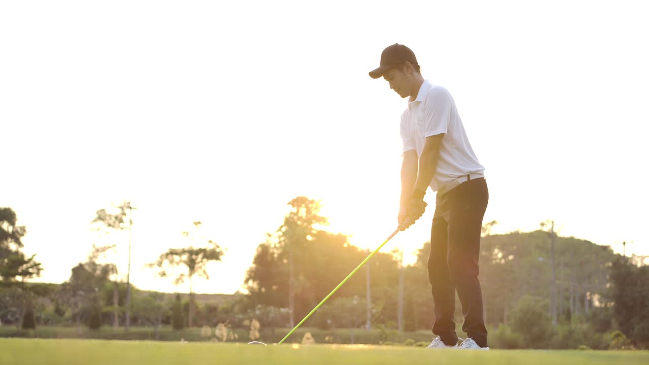 아시아 남성 골퍼가 드라이버를 들고 페어웨이에서 티오프를 한 후 공을 지켜보고 슬로모션으로 축하합니다.