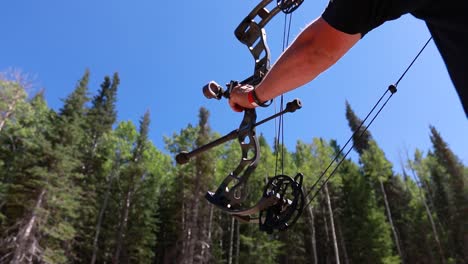 slow motion shot of an archer shooting an arrow in the mountains 4