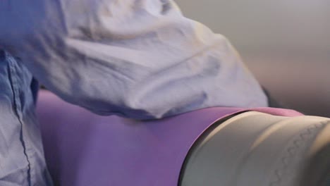 close-up of a person's hand carefully cleaning a surface with a purple cloth