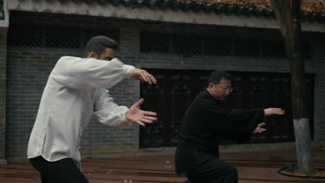 two men practicing tai chi outdoors