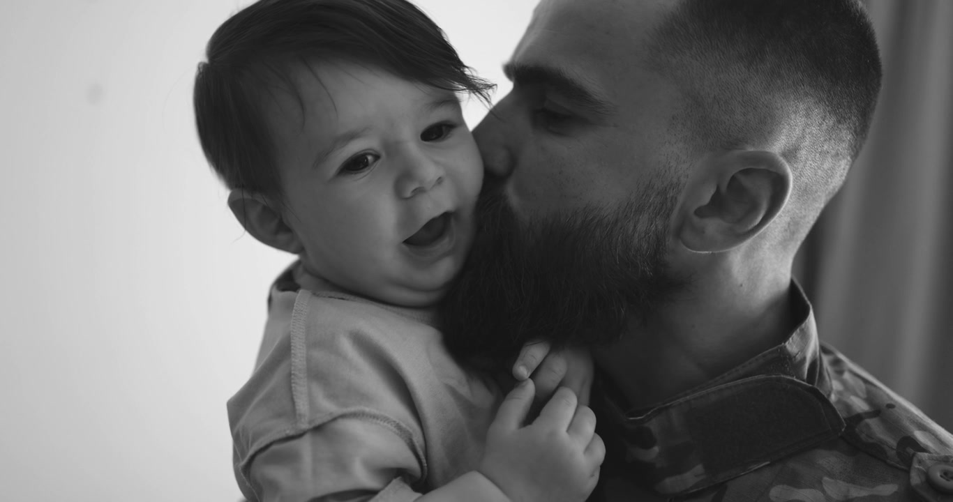 Padre amorevole bacia la guancia del suo bambino in bianco e nero