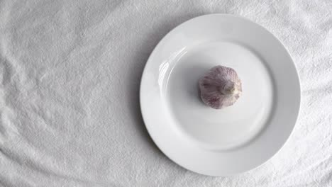 Garlic-on-white-ceramic-plate-on-white-table-mat