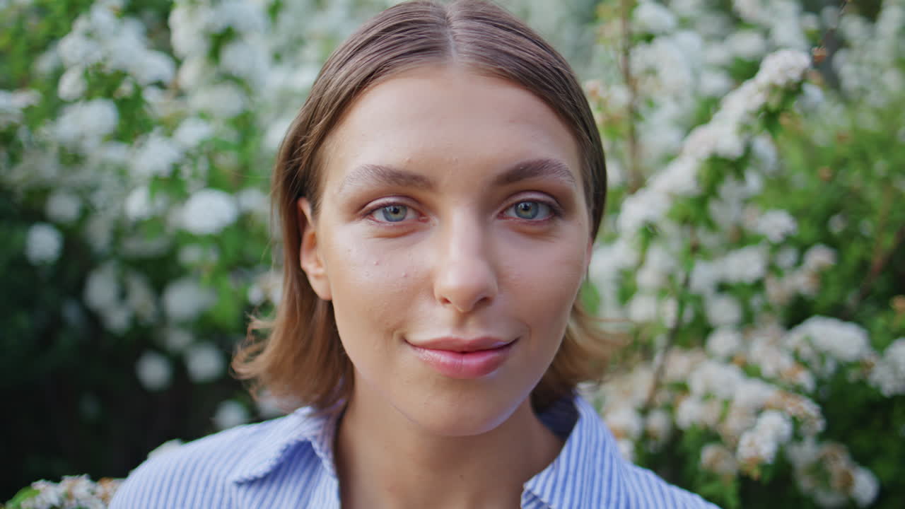 Portrait dreamy woman looking camera amidst garden bloom. Romantic brunette