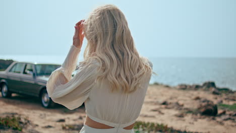 mujer relajada caminando por la costa en las vacaciones de verano de primer plano. niña yendo a coche retro