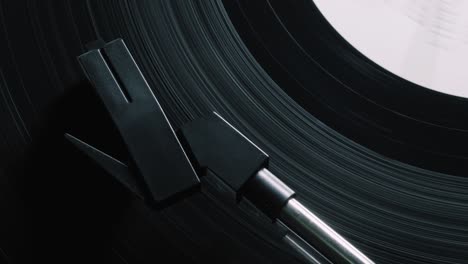 vinyl record on turntable, viewed from above. close-up. pick-up lifts off. 4k