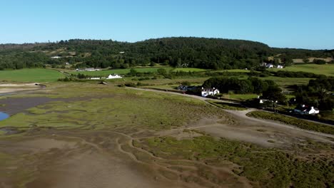 Aerial-panning-view-Traeth-Coch-Pentraeth-Welsh-rural-marshland-scenic-farming-countryside-at-sunset