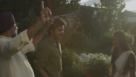 joyful indian family dancing outdoors in traditional attire