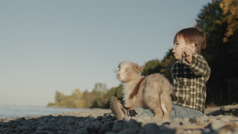 a purposeful boy of two years throws a stone into the sea. rear view, slow motion video