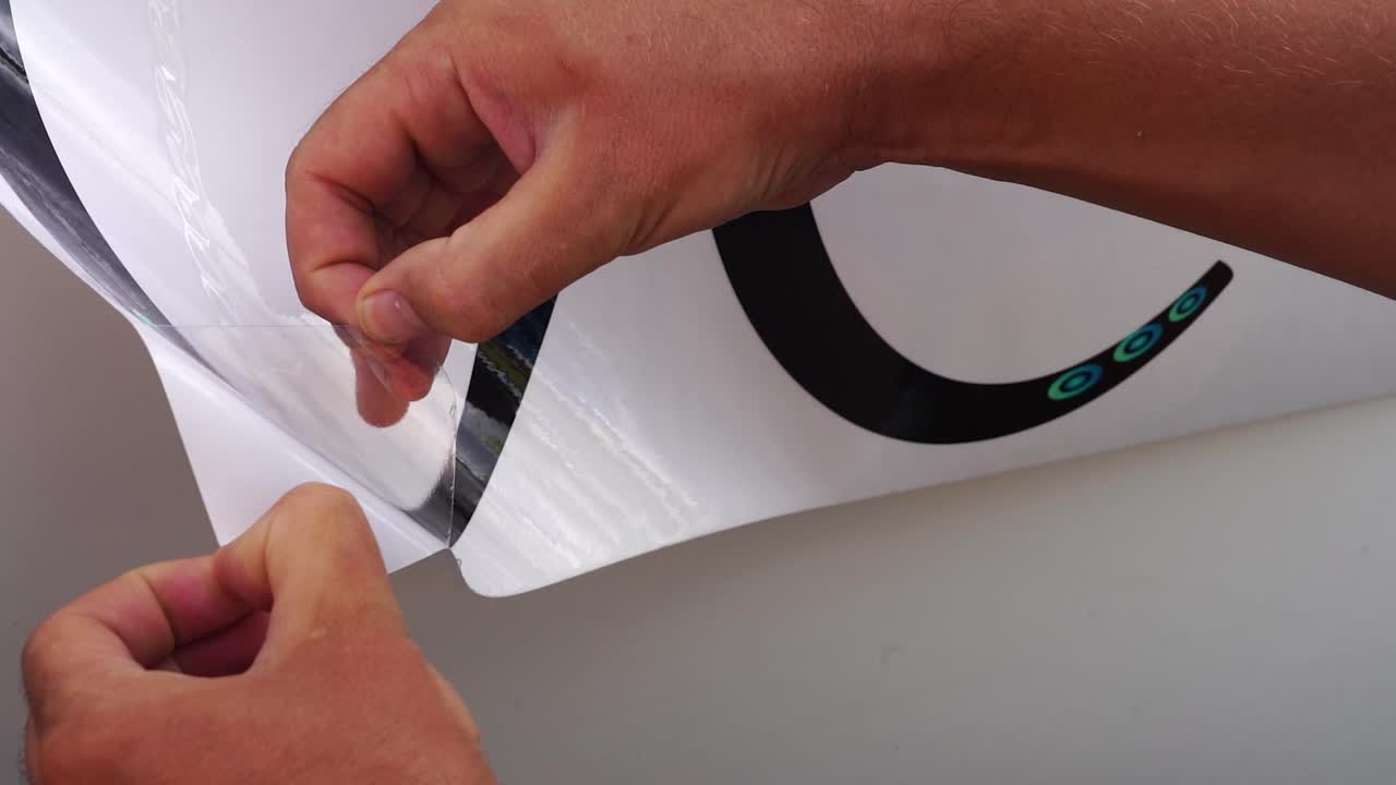 Custom Graphics, Man's hands Peeling Back Off Of Vinyl Decal