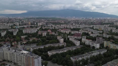 Toma-Aérea-De-Una-Ciudad-Llena-De-Antiguos-Edificios-De-Apartamentos-De-La-Era-Comunista-Con-Muchos-árboles-Verdes-En-El-Medio