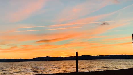 lapso de tiempo dorado del atardecer en la playa de san harbour, lago tahoe, nevada, usa nubes de la tarde alejándose rápidamente, rodando nubes oscuras al atardecer, rojo púrpura naranja azul rosa puesta de sol cielo nube lapso de tiempo