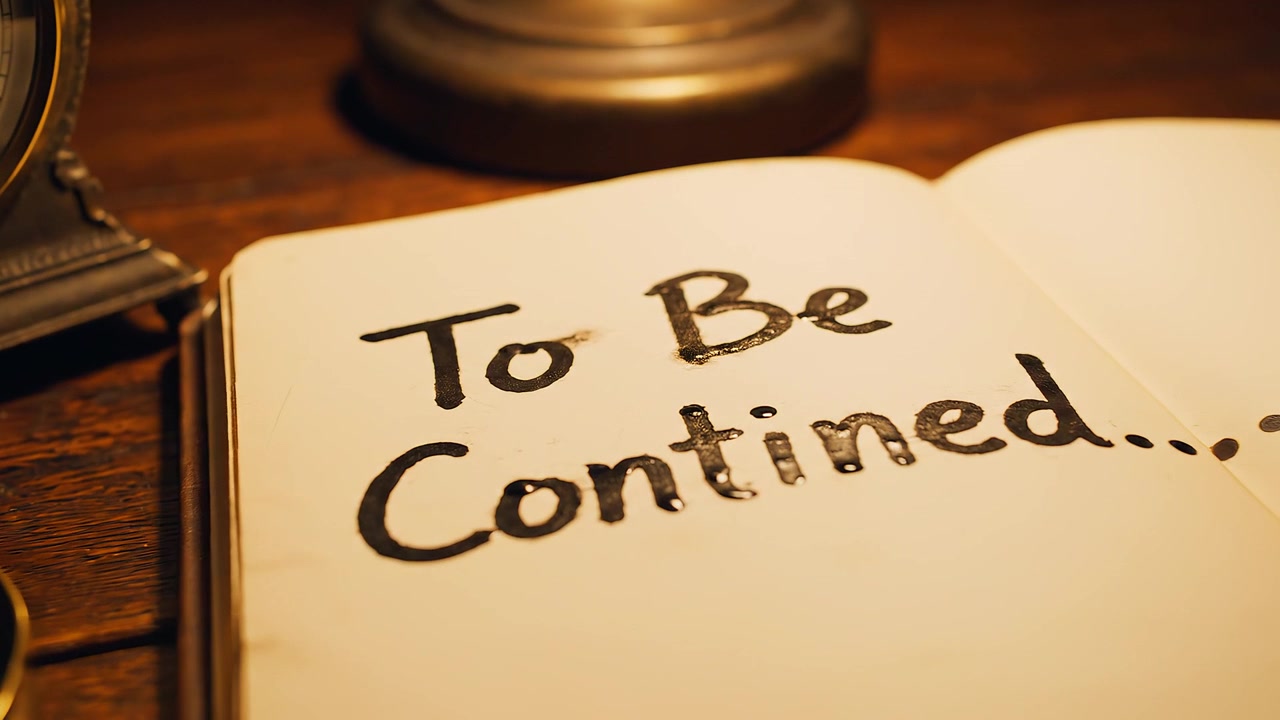 To Be Continued Message in Open Notebook on Antique Desk