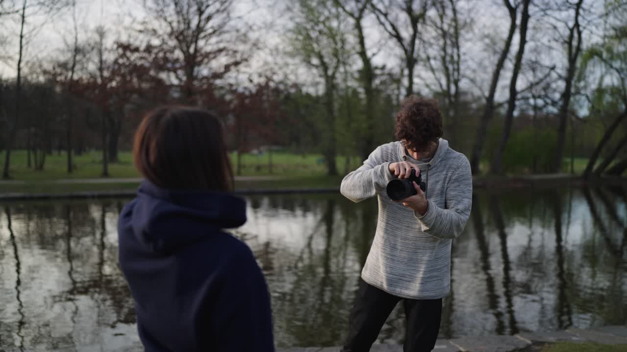 sesión de fotos al aire libre cerca del estanque del parque, mujer posa frente al fotógrafo