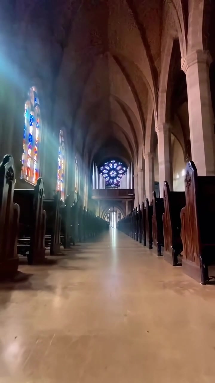 Interno maestoso di una chiesa con raggi di sole e vetrate colorate
