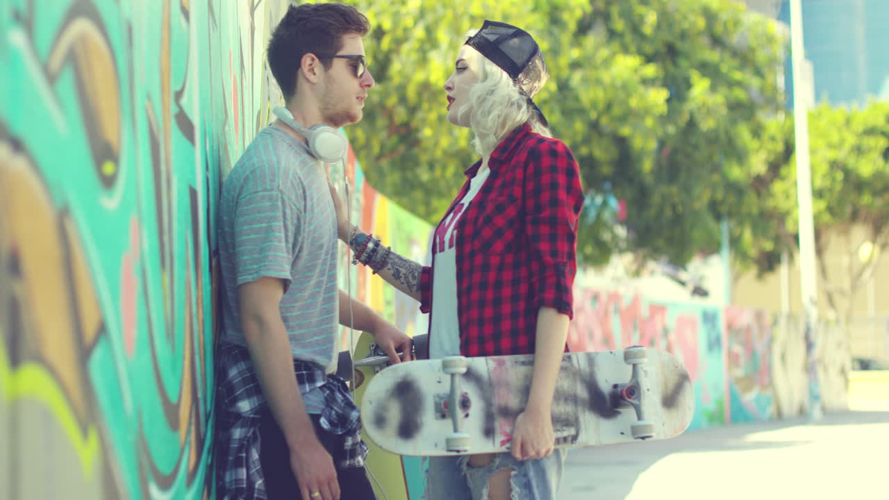 pareja joven de moda charlando en una calle urbana
