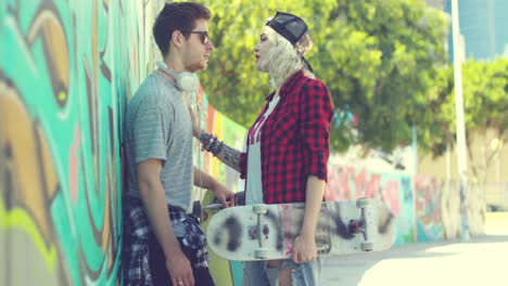 Trendy-young-couple-chatting-in-an-urban-street