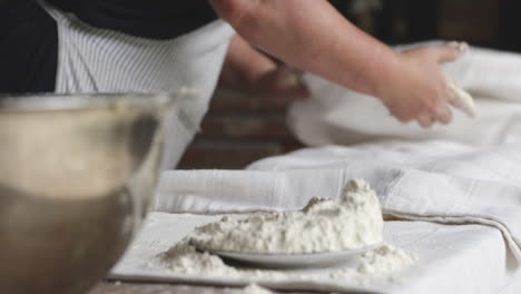 woman baker covers the bread dough with a clean white cloth