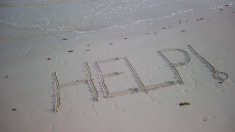 help! inscribed in the sand on a beach