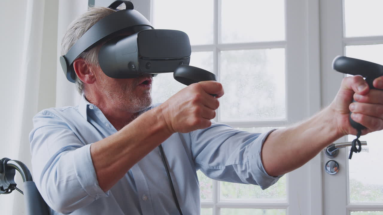 hombre discapacitado en silla de ruedas en casa con auriculares de realidad virtual sosteniendo controladores de juegos