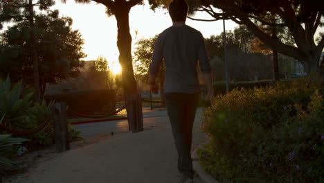 man walking in park at sunset