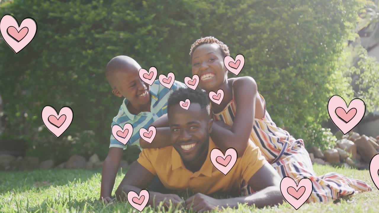 Animation of hearts over happy african american family in garden
